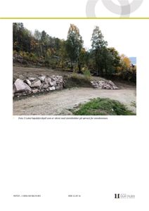 Fotografi av et lokalt høydeforskjell sikret med steinblokker på eiendom.