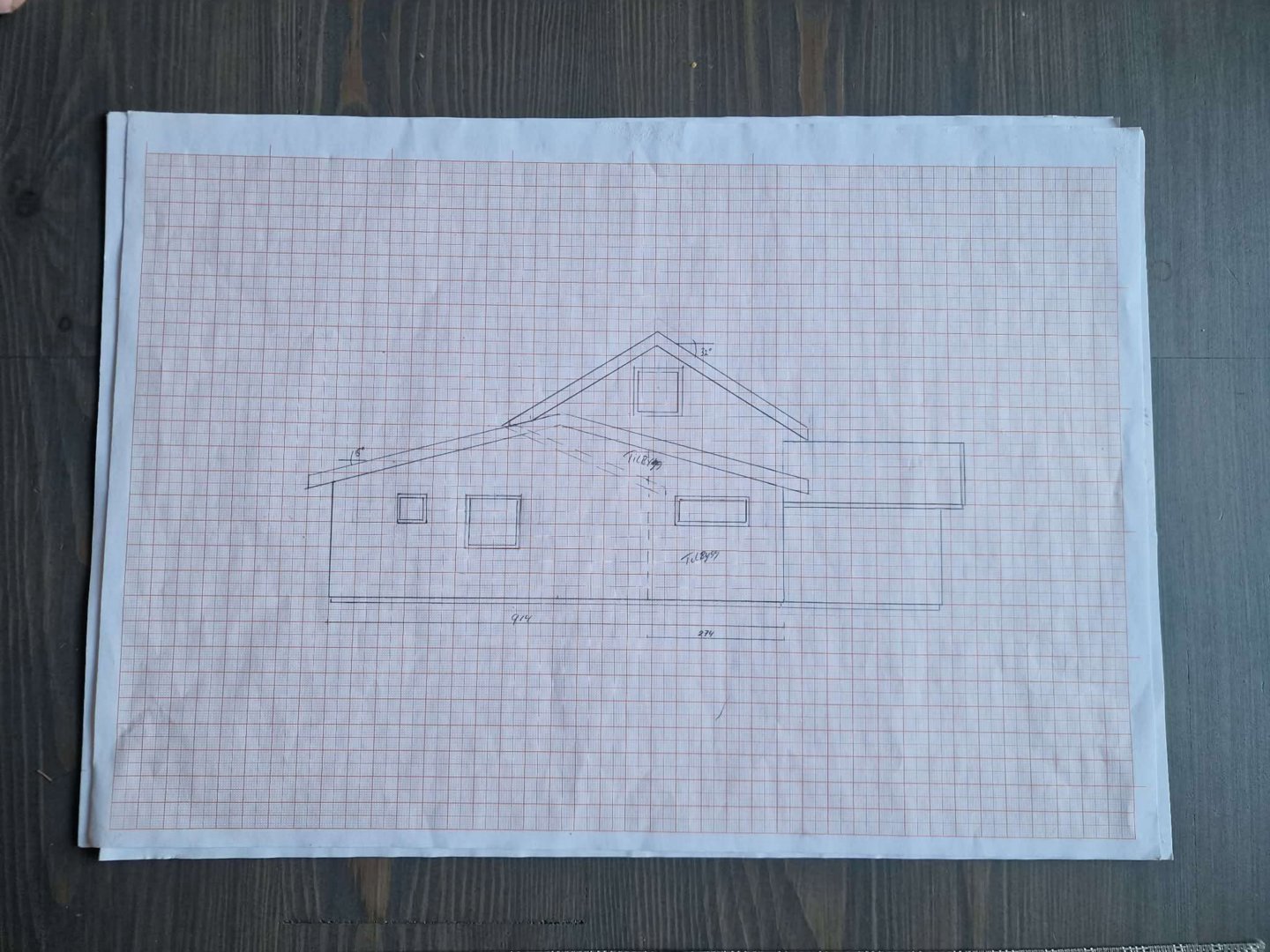 En håndtegnet fasadetegning av en enebolig, tegnet på rutenett.