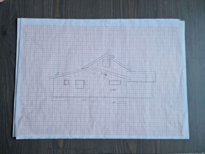 En håndtegnet fasadetegning av en enebolig, tegnet på rutenett.