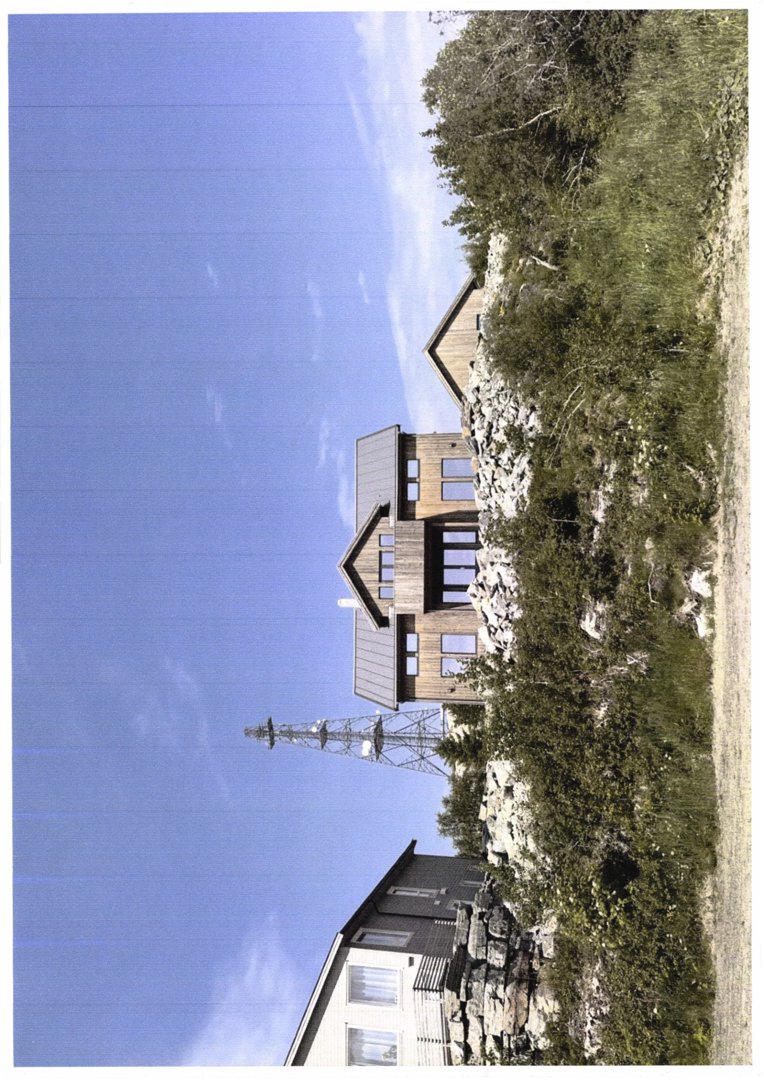 Fotografi av en bygning i tre med et tak, sett fra siden mot en blå himmel og vegetasjon.