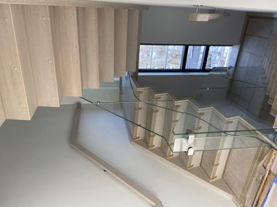 Fotografi av en trapp med glasshåndtak under bygging eller renovering.