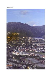 Et fotografi tatt 27. juli 1962 som viser et boligområde med fjell i bakgrunnen.