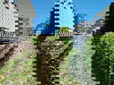 Fotografi av en bygning og en utendørs område med en blå container og trapper.