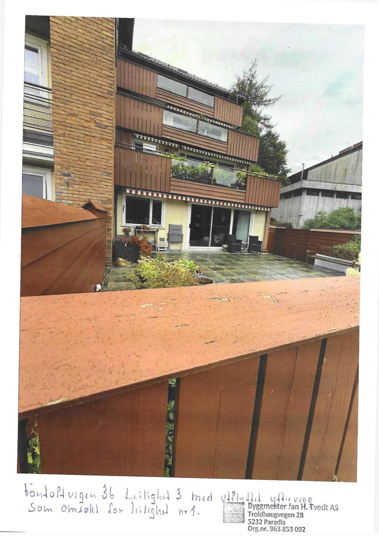 Fotografi av en eksisterende bygning sett fra bakgårdssiden, med håndskrevet notat om omgjort yttervegg.