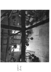 Sort-hvitt fotografi av et interiør med synlige bjelker, møbler og gulvpanel.