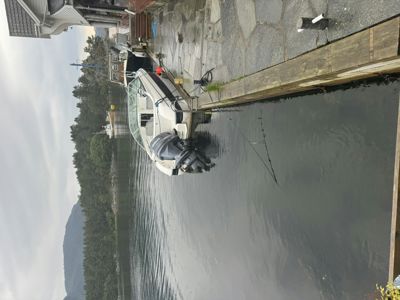 Fotografi av en båt som er festet ved en kai i en havn eller ved en vannkant.