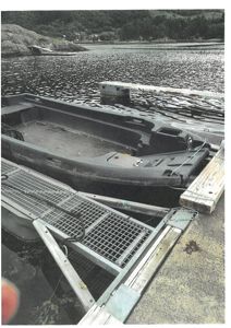 Fotografi av en båt som er festet til en kai ved vann.