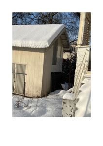 Fotografi av en hvit bygning med snø på taket og i omgivelsene.