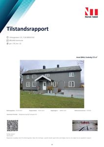 Fotografi av en grå fasettert tømmerhytte med hvite vinduer og en hvit frontdør. Bildet er tatt fra et lavt vinkel og viser huset med en grønn hage i forgrunnen.