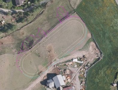 Situasjonsplan eller flyfoto med overlagte tegninger som viser en planlagt bygning eller anlegg på en tomt.