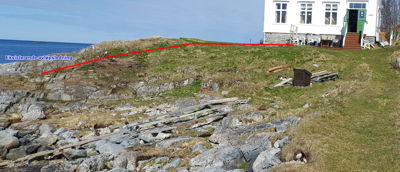 Fotografi av et hus ved kysten med en markert rød linje som viser en eksisterende avløpsledning.