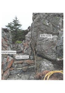 Fotografi av en steinmur (forstøtningsmur) og en trapp i terreng ved en stor bergvegg (Berg Nord).