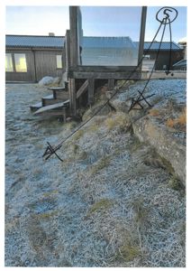 Fotografi av en bygning sett fra siden, med håndtegnede markeringer (pil og 'X') på bildet.