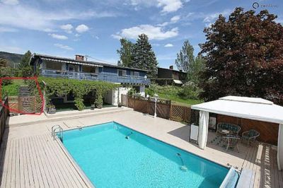 Fotografi av en villa med svømmebasseng og uteplass.