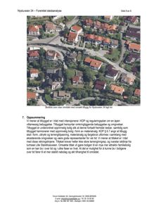 Et skråfoto som viser et boligområde med hus, veier og trær.