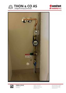 Fotografi av en rørinstallasjon med kobber- og messingrør, ventiler og et målerinstrument montert på en vegg.