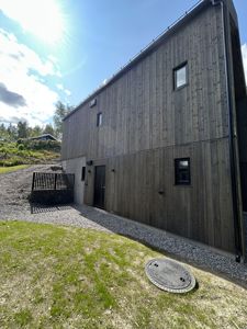 Fotografi av en moderne bygning med trefasade sett fra siden.