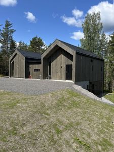 Fotografi av en moderne, trebekledt bygning sett fra utsiden.