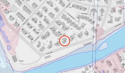 Situasjonsplan som viser tomtegrenser, bygninger og gater i et område. Et spesifikt hus (nr. 17) er markert med en rød sirkel.