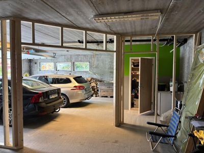 Fotografi av en garasje eller kjeller under ombygging, med oppstilt tømmerkonstruksjon for nye vegger og dører.