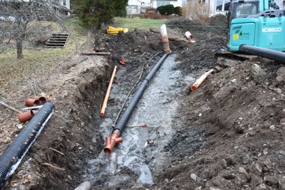 Fotografi av en graving med rørleggingsarbeid i gang.