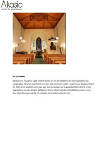 Fotografi av kirkerommet sett fra inngangen mot alteret, med fokus på lysforholdene over koret.