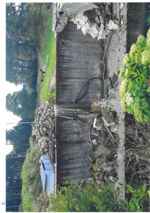 Fotografi av en utvendig vegg i en bygning, sannsynligvis en kjeller- eller underjordisk del, med tilhørende utemiljø.