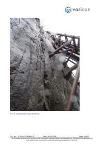 Fotografi av en steil fjellvegg med en metallkonstruksjon (rørledning) som er festet til den.