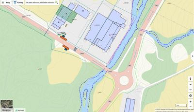 Kartutsnitt fra et digitalt kartsystem (Norskart) som viser en bygning, en vei, en elv og terrengforhold.