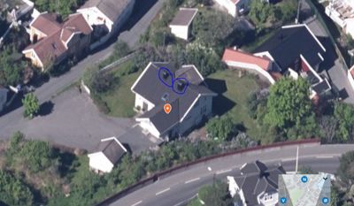 Flyfoto eller satellittbilde av en boligbebyggelse med en markert tomt og hus.