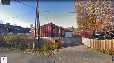 Fotografi av en rød enebolig sett fra gaten.