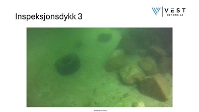 Fotografi fra et inspeksjonsdykk under vann, som viser en del av en betongkonstruksjon og en rørfittings.