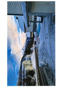 Fotografi av en bygning og tomt i snø, med håndskrevne notater (adresse og dato) på bildet.