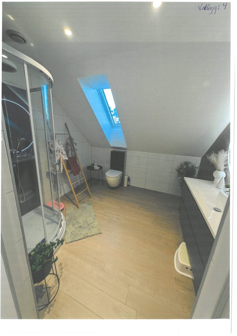 Fotografi av et bad med dusj, toalett og vask.