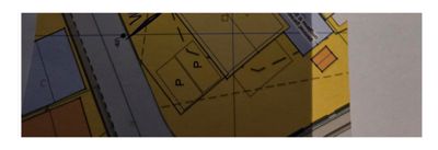 Situasjonsplan som viser tomt, bygningsspor, veier og parkeringsplasser.