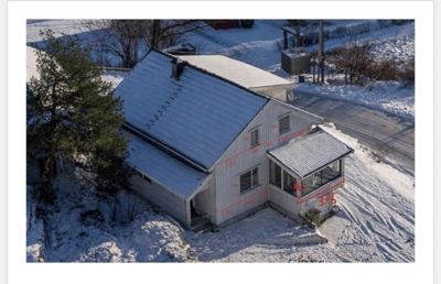Fotografi av en hvit, toetasje villa med etasje og takterrasse, sett fra lufta. Bildet har røde målelinjer og tekst (f.eks. '375') overlagt, som indikerer at det er brukt til måling eller dokumentasjon.