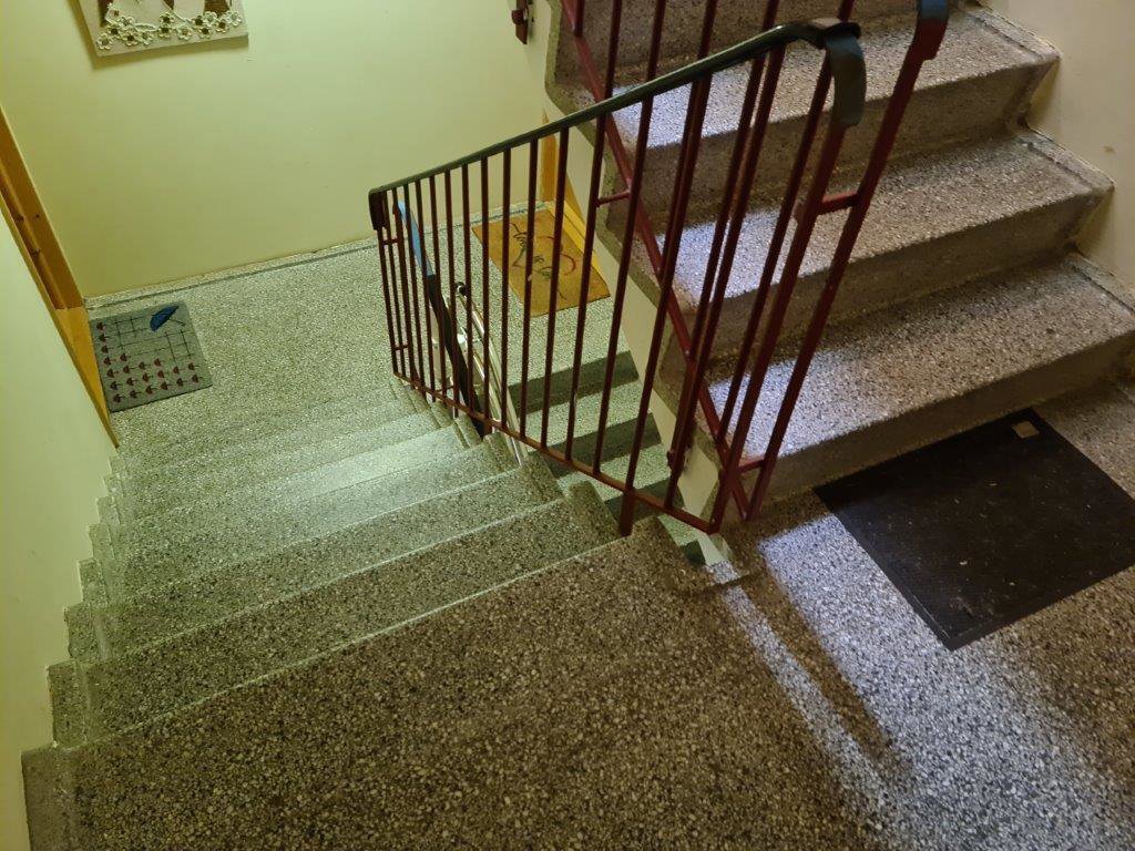 Fotografi av en trapp med gulv, trappetrinn og håndtak.