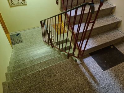 Fotografi av en trapp med gulv, trappetrinn og håndtak.