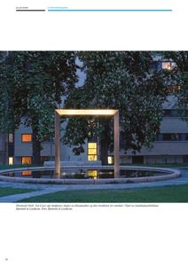 Fotografi av Pilestredet Park med en opplyst skulptur i forgrunnen og et bygg i bakgrunnen.