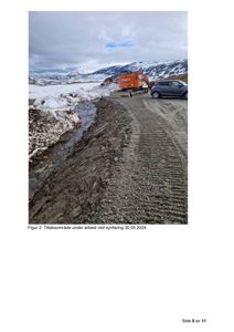 Fotografi av et utendørs område med snø, en grusvei, en bil og en gule byggeutstyr (graver). Bildet viser et tiltaksområde under arbeid.