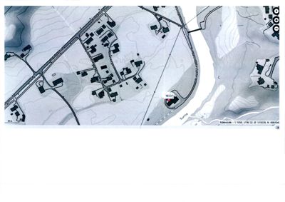 Flyfoto eller ortofoto av et område med bygninger, veier og terrengforhold.