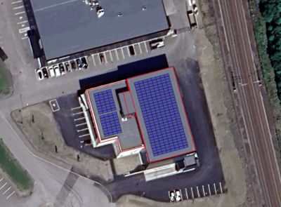 Satellittbilde (flyfoto) av en bygning med overlagte tegninger som viser plassering av solcellepaneler på taket.