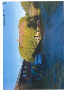 Fotografi av en eksisterende bygning (hus) sett fra siden, med bil og trær i forgrunnen.