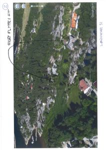 Google Earth-snapshot som viser et område med hus, skog og vann. En håndskrevet pil peker på et hus med teksten 'HUSSET FLYTTES HIT'.