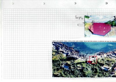 Fotografi av en bygning (rødt tak) sett fra luften, med en rød rektangel rundt bygningen og håndskrevne notater.