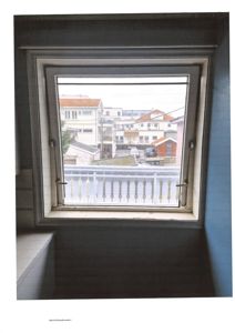 Fotografi av et vindu sett fra innvendig, med utsikt over nabolaget.