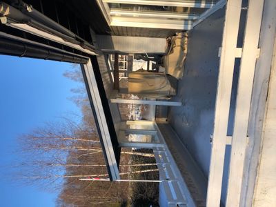 Fotografi av en utvendig del av en bygning, sannsynligvis en veranda eller en del av fasaden under ombygging eller vedlikehold.