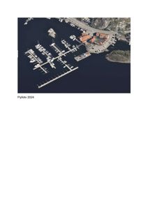 Flyfoto fra 2024 som viser en havn med båtplasser, en bygning med oransje tak og omgivende kystlandskap.