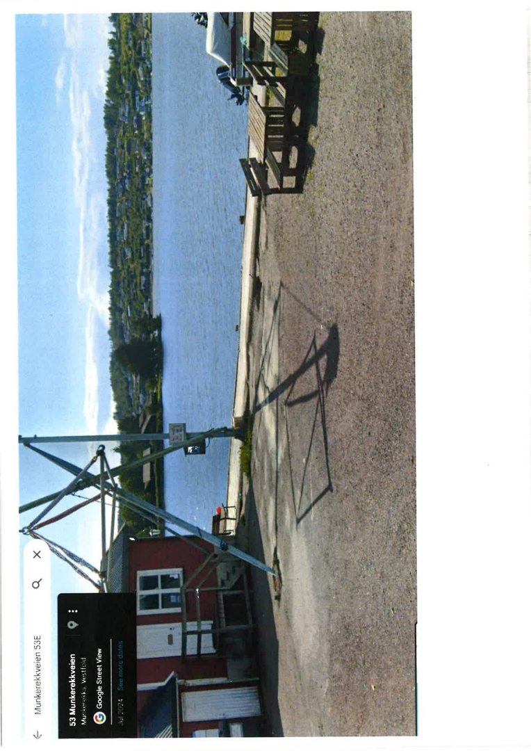 Fotografi av en bygning ved vannet, sett fra en vinkel som viser fasade og omgivelser.