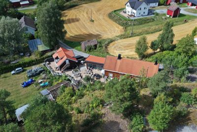 Luftfoto av en bolig og tomte med omgivelser, inkludert nabolag og landbruk.